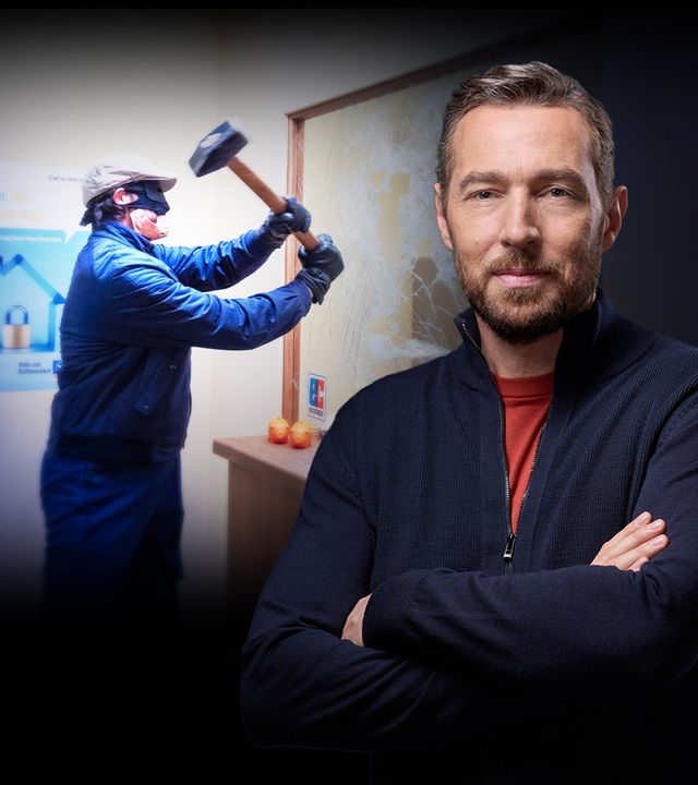 Sven Voss vor einem Foto von einem Bankräuber, der eine Scheibe mit einem Hammer zerschlägt. 