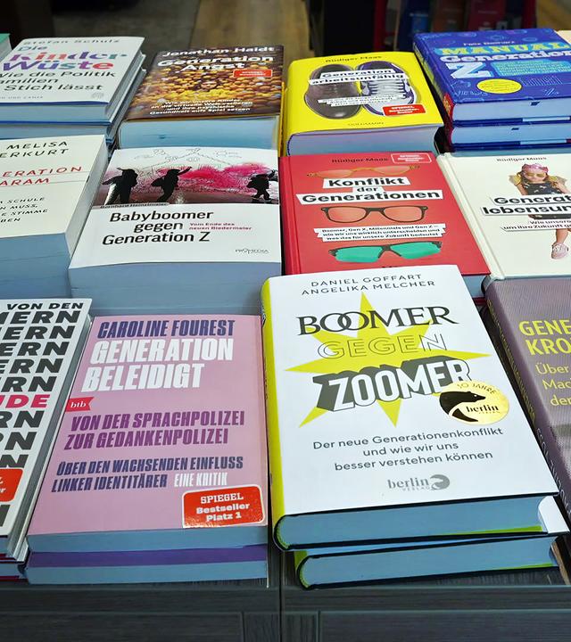 Bücher in drei Reihen übereinander auf einem Tisch liegend