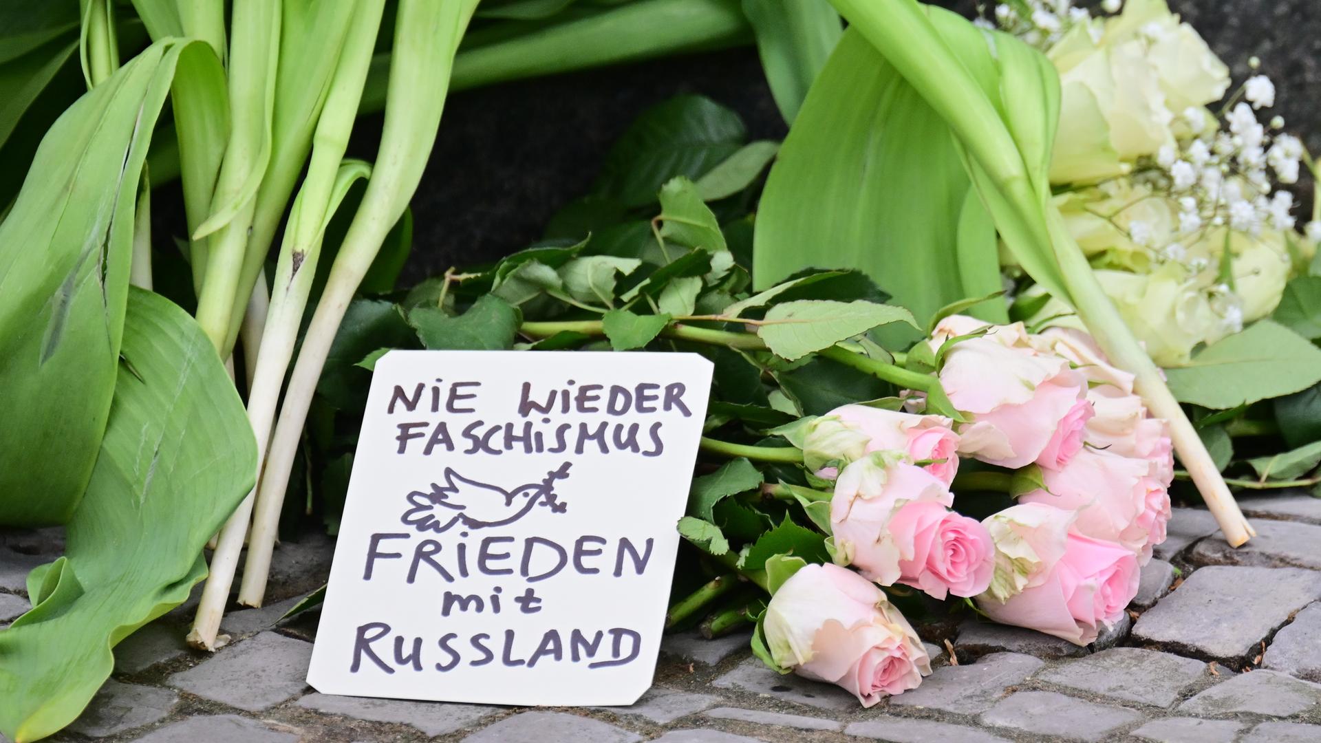 Ein Schild mit der Aufschrift Nie wieder Faschismus - Frieden mit Russland liegt vor einem Eingang zur russischen Botschaft.