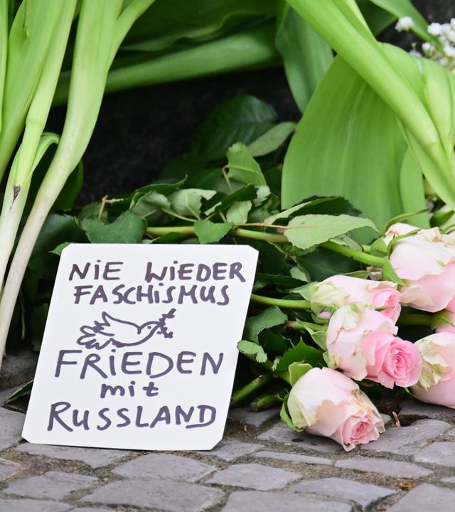 Ein Schild mit der Aufschrift Nie wieder Faschismus - Frieden mit Russland liegt vor einem Eingang zur russischen Botschaft.