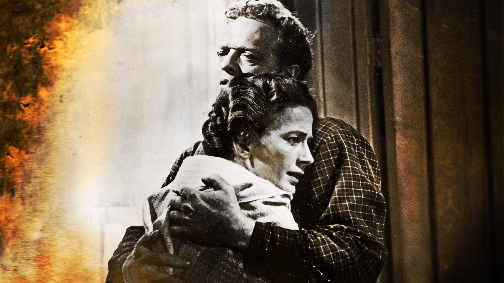 Alice Evans (Leora Dana), mit flehendem Gesichtsausdruck, und Dan Evans (Van Heflin) umarmen sich.