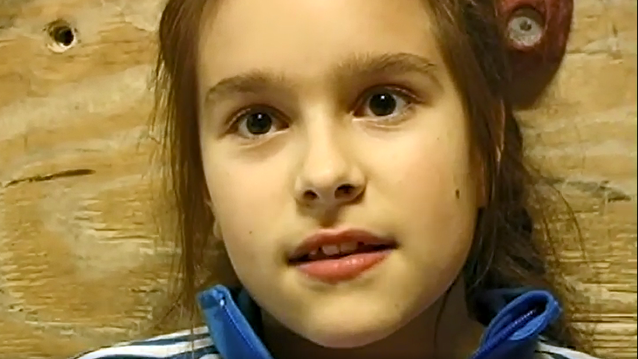 Majas Synchronsprecherin Zalina Sanchez in Nahaufnahme vor einer Kletterwand in der Boulderhalle.