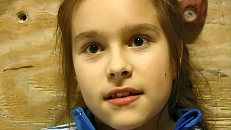 Majas Synchronsprecherin Zalina Sanchez in Nahaufnahme vor einer Kletterwand in der Boulderhalle.