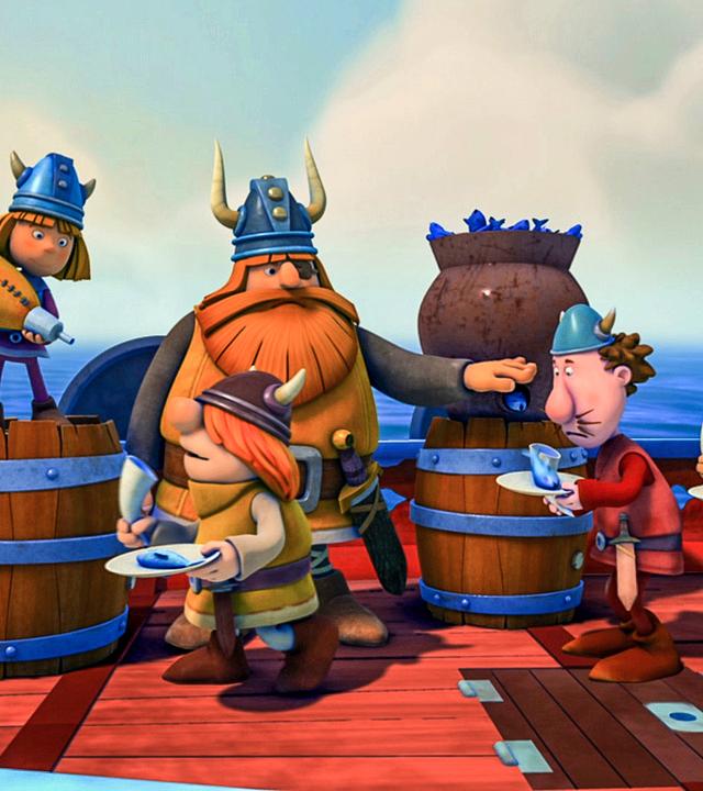 Die Wikiner stehen mit Tellern in der Hand an Bord des Schiffes, wo Halvar jedem einen Fisch austeilt. Wickie schenkt aus einem Schlauch Trinken ein. Alle sehen unglücklich aus.