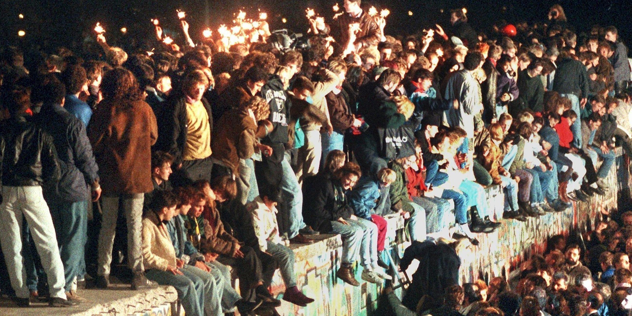 Archiv: Menschenmassen an und auf der Berliner Mauer, teils sitzend, teils stehend