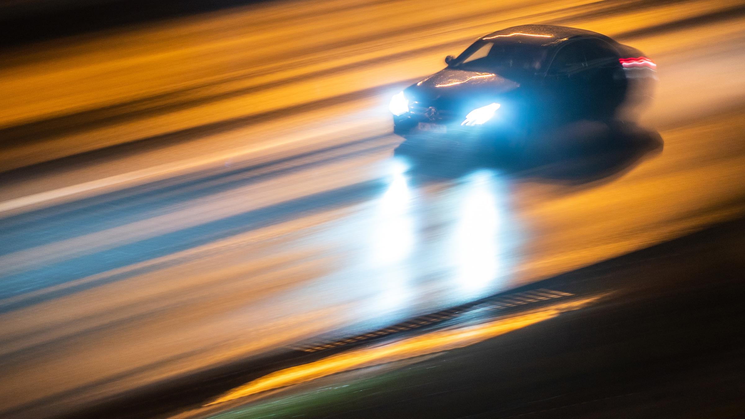 Ein Fahrzeug rast abends über die regennasse Autobahn A661 in Frankfurt am Main