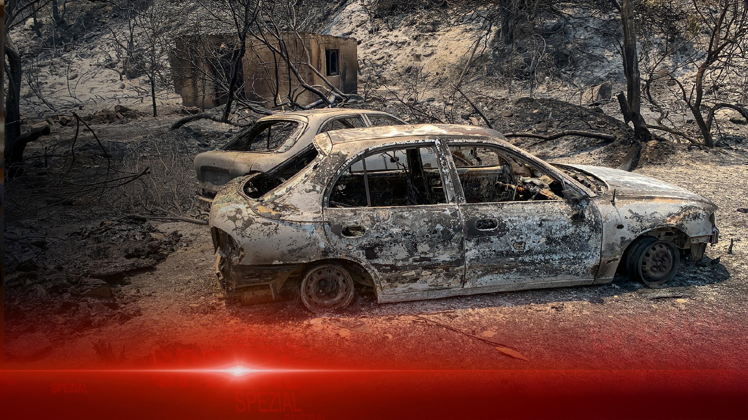 Verbrannte Autowracks stehen nach katastrophalen Waldbränden auf einer Straße der griechischen Insel Rhodos