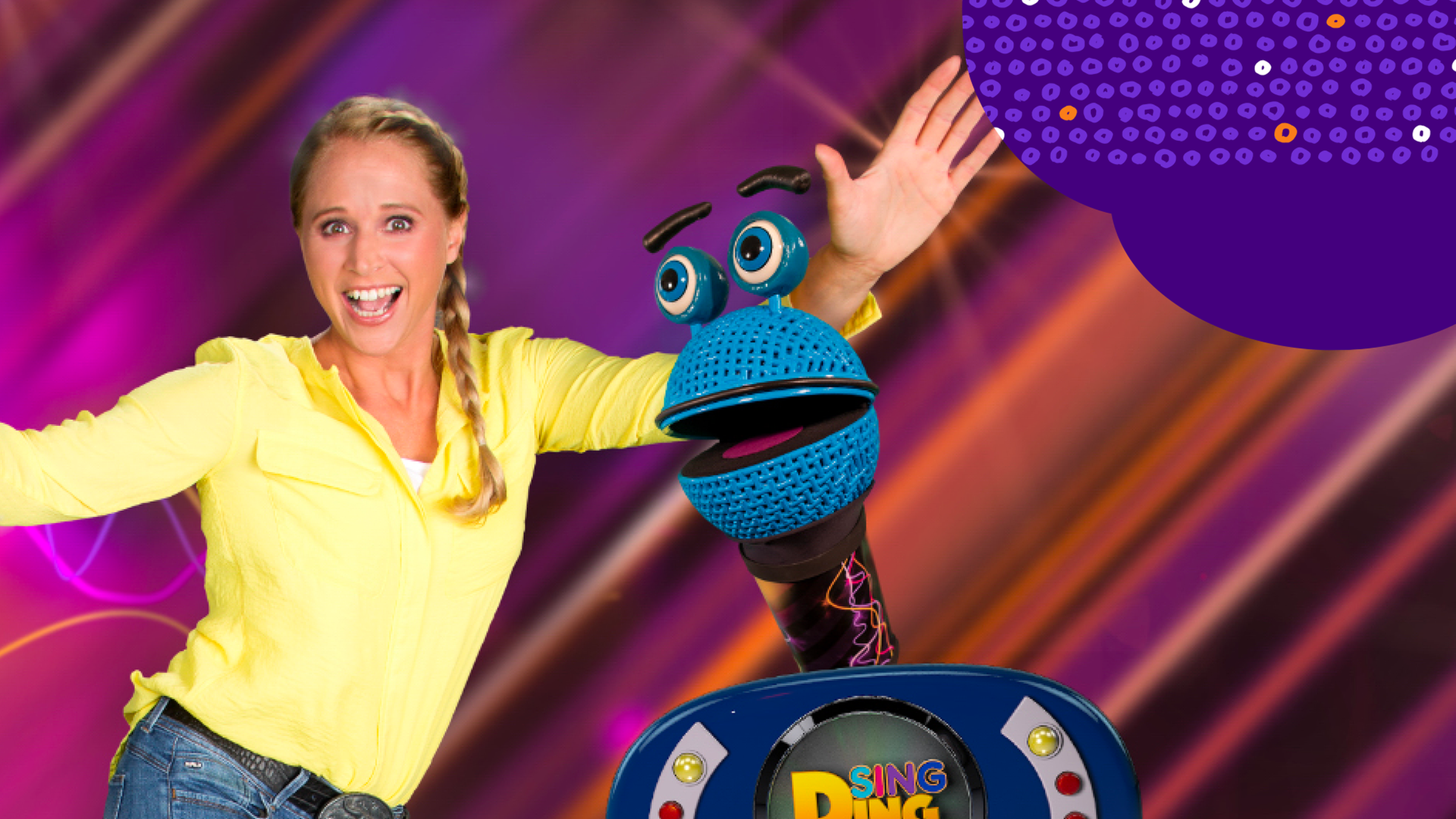 Die Moderatorin von Singalarm, Singa, hebt grüßend die Hände. Eine Mikrofon-Puppe guckt hinter einem Spielzeug-Radio hervor.
