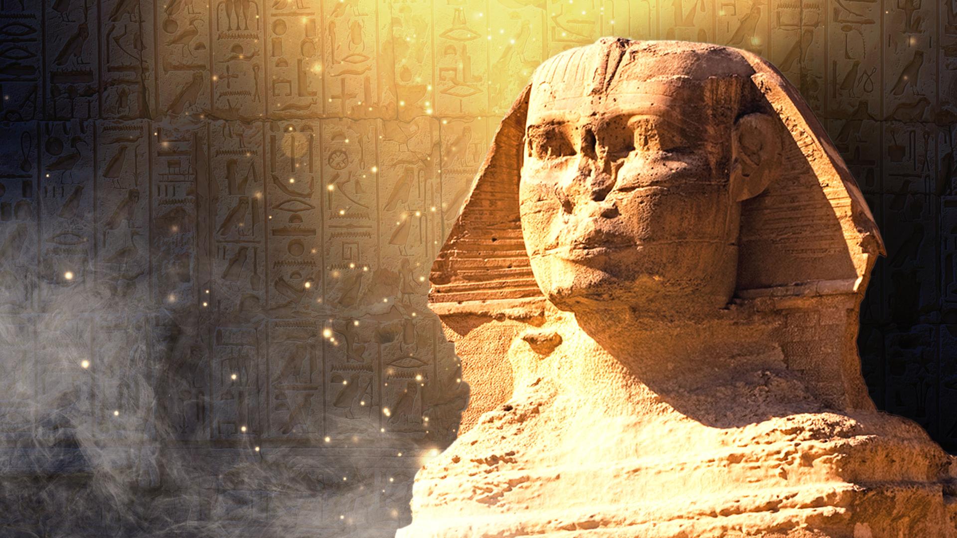 Die Sphinx vor einer Hieroglyphenwand mit Nebel und Glitzereffekten.