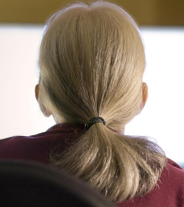 Ina Steiner sitzt mit dem Rücken zur Kamera vor einem hell erleuchteten Bildschirm.