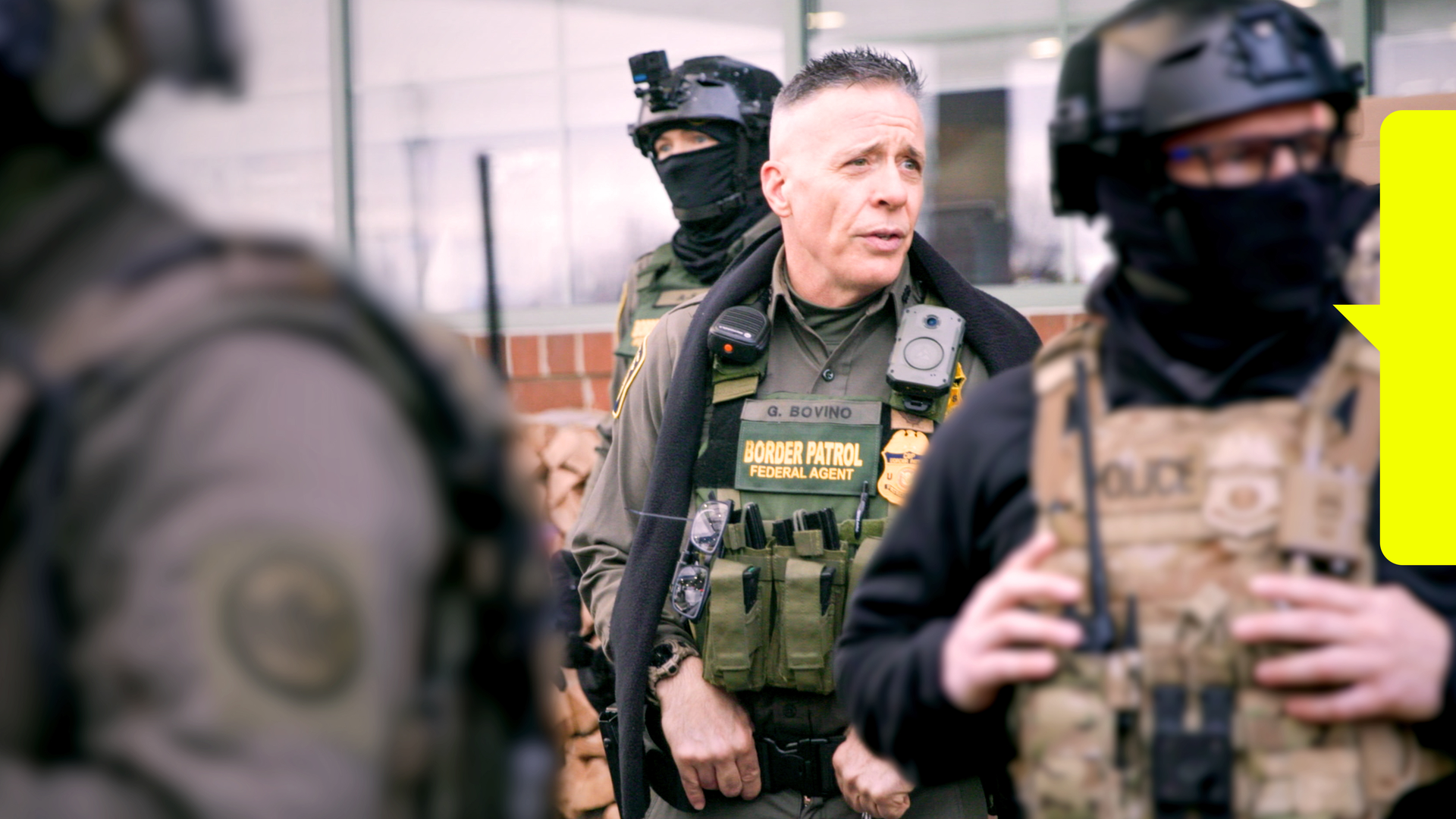 In der Mitte ein Federal Agent der Border Patrol, neben ihm mehrere vermummte Polizisten
