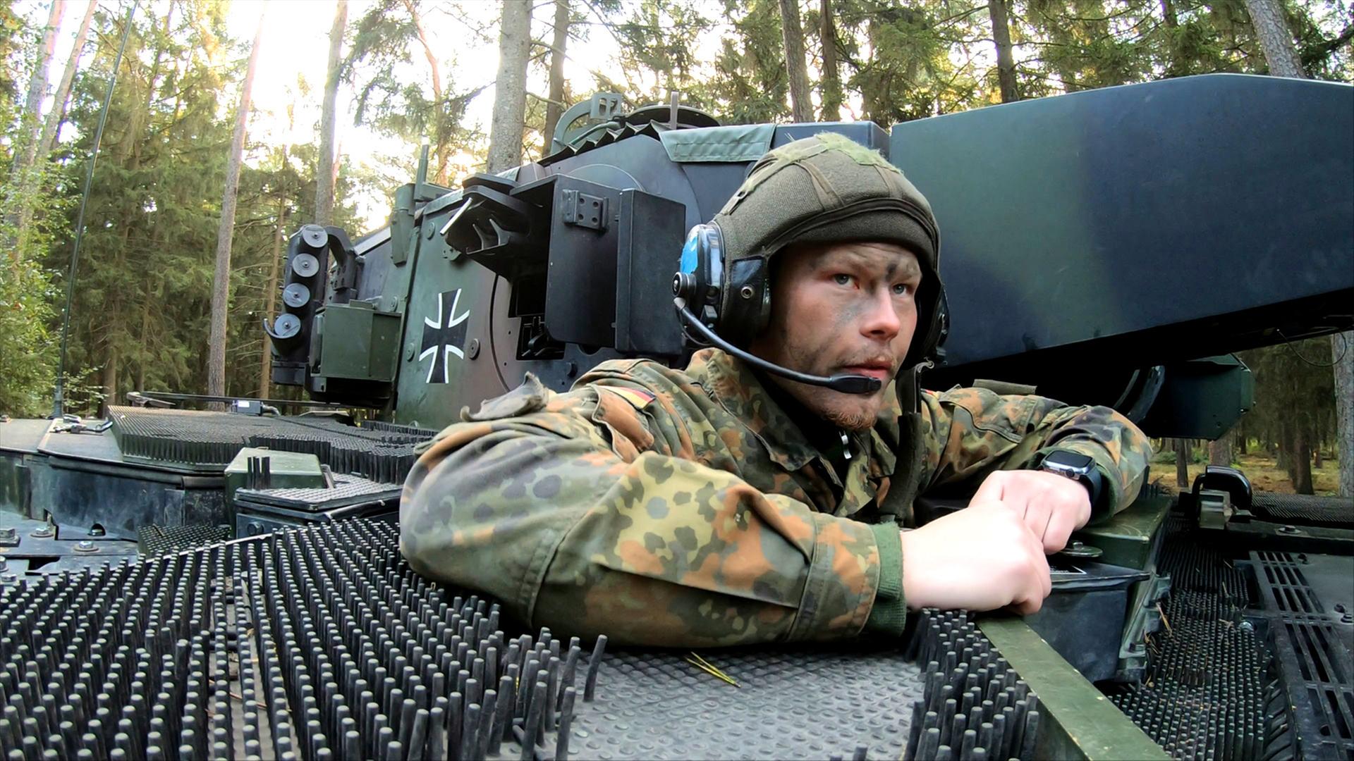 Bei einer Übung für Panzergrenadiere schaut ein Soldat aus einem Panzer heraus.