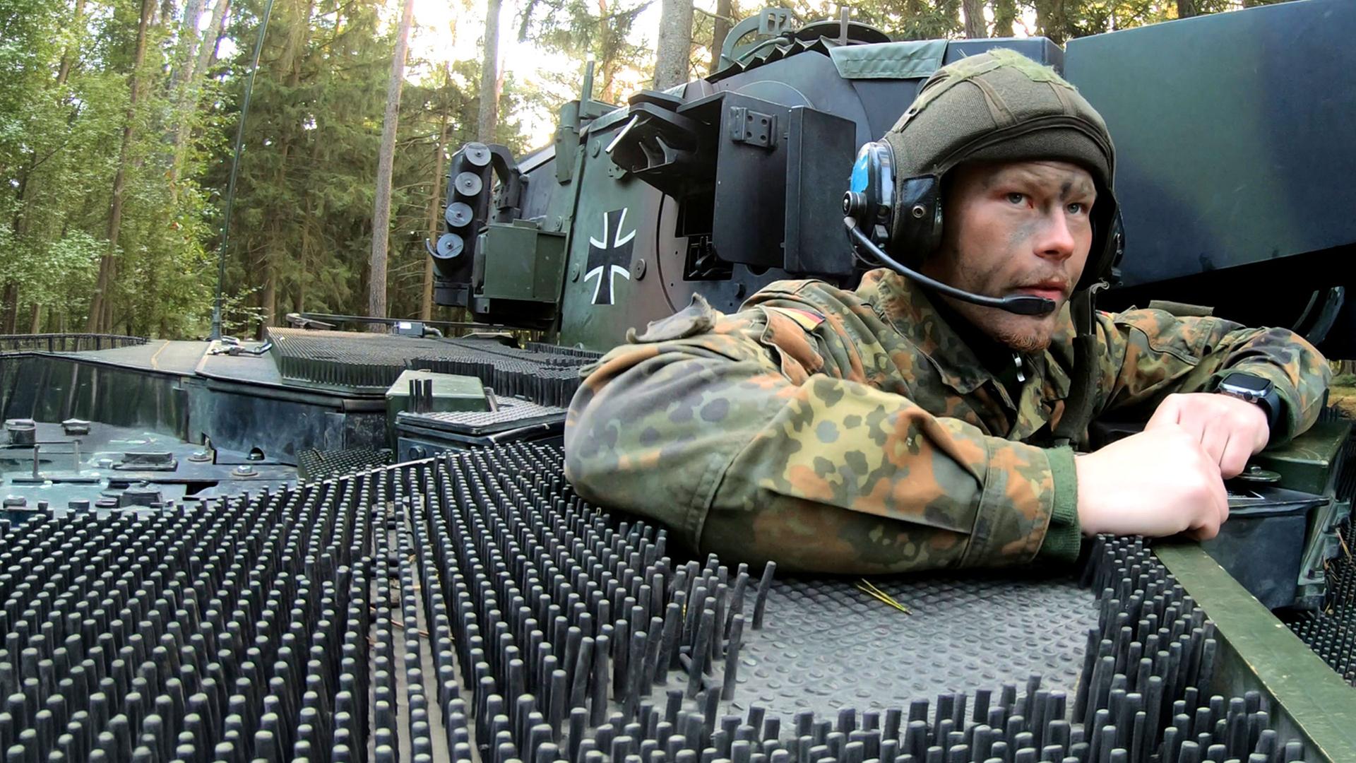 Bei einer Übung für Panzergrenadiere schaut ein Soldat aus einem Panzer heraus.
