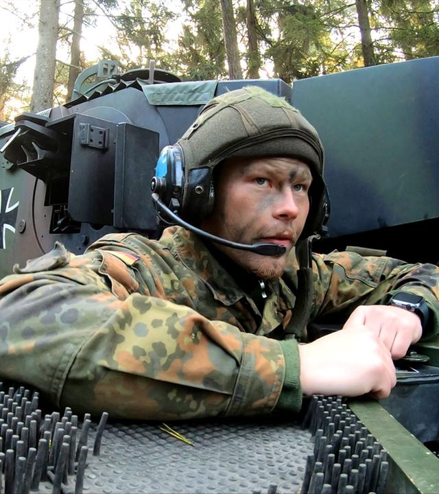 Bei einer Übung für Panzergrenadiere schaut ein Soldat aus einem Panzer heraus.