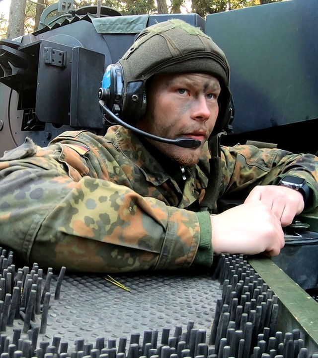 Bei einer Übung für Panzergrenadiere schaut ein Soldat aus einem Panzer heraus.