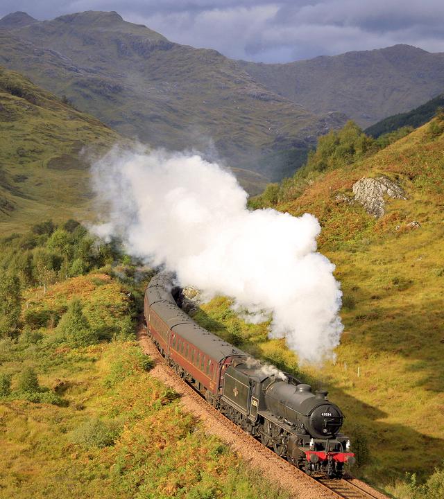 Ein Zug mit dem Ziel Fort William fährt durch die schottische Landschaft.