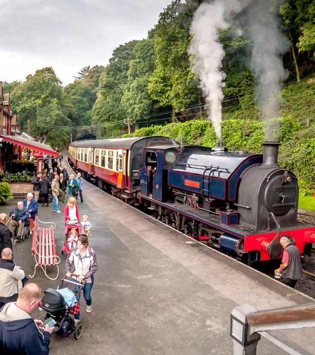 Menschen warten an der Haverthwaite Station in England auf den Zug.