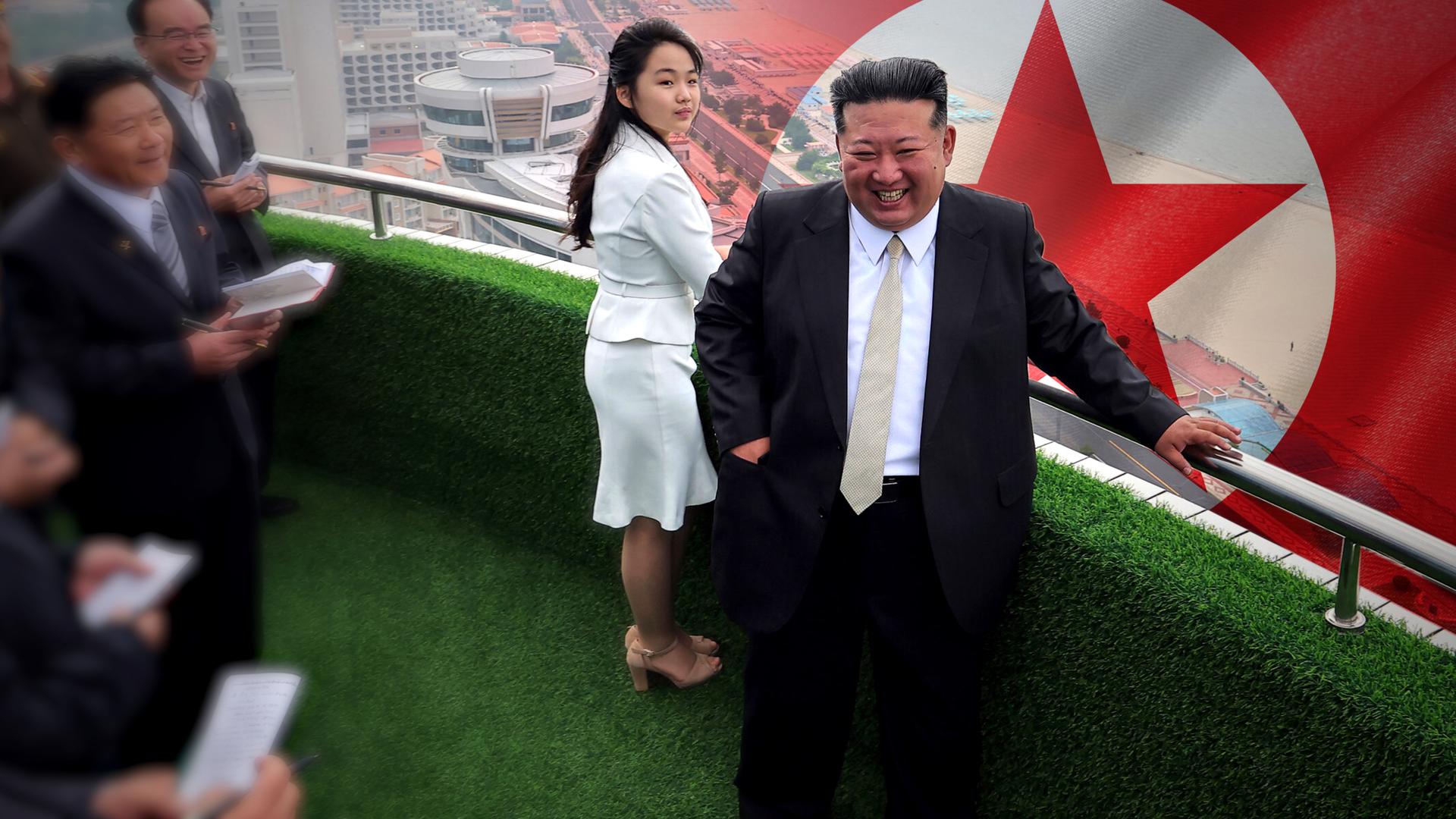 Kim Jong Un und seine Tocher Ju-Ae bei der Eröffnung eines Touristenresorts an der Küste Nordkoreas im Jahr 2025; im Hintergrund groß die Flagge von Nordkorea