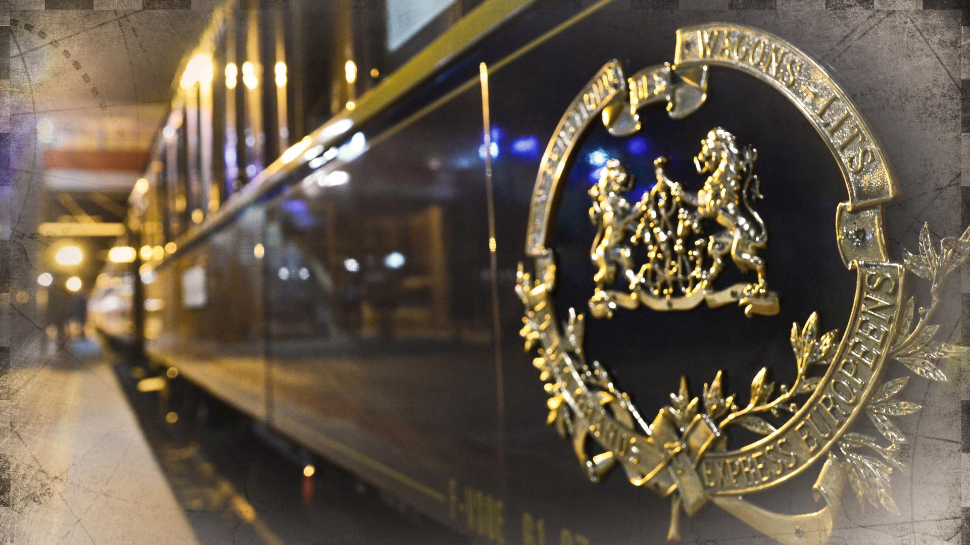 Ein Waggon des Orient-Express an einem Bahnhof, bei Nacht; an den Bildrändern leichte Überblendung mit einer alten Landkarte.