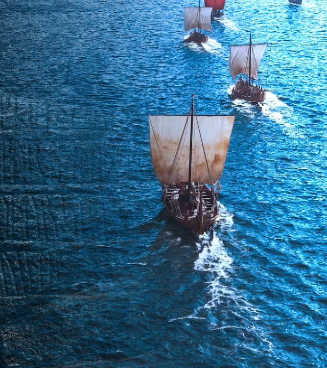 Mehrere historische Segelschiffe mit rot-weißen Segeln fahren auf offenem Wasser