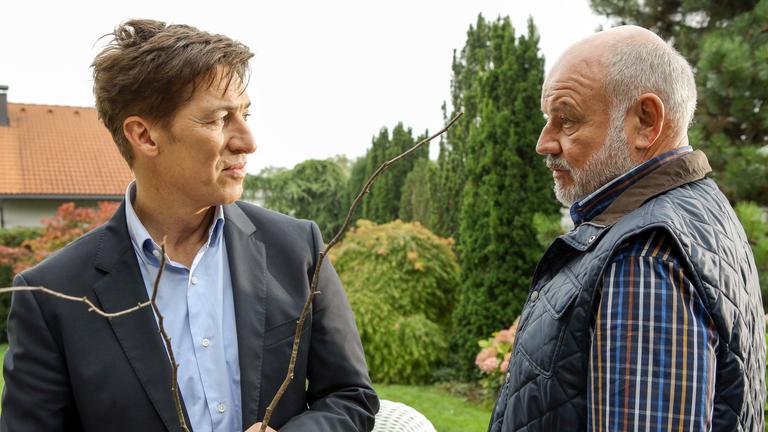 "Alles Fleisch ist Gras": Nathan Weiß (Tobias Moretti) und Anton Galba (Wolfgang Böck) stehen sich im Garten gegenüber und schauen sich in die Augen. Nathan Weiß hält einen Stock in den Händen.
