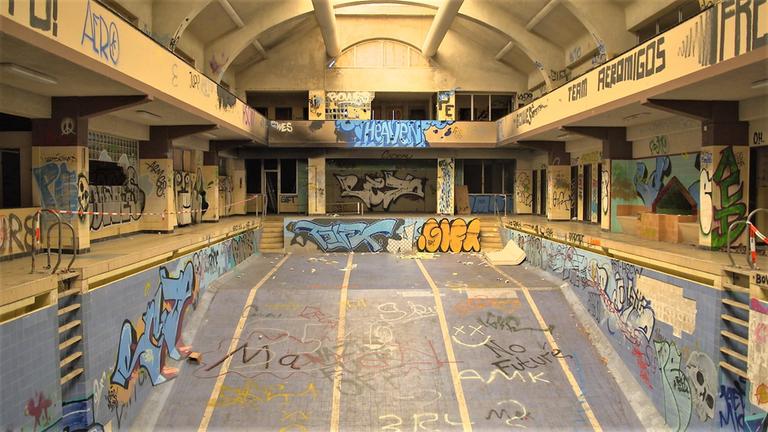  "ZDFzoom: Schwimmbäder in Not - Von Badespaß und leeren Kassen": Blick in ein komplett marodes Schwimmbecken mit vielen Graffitis.