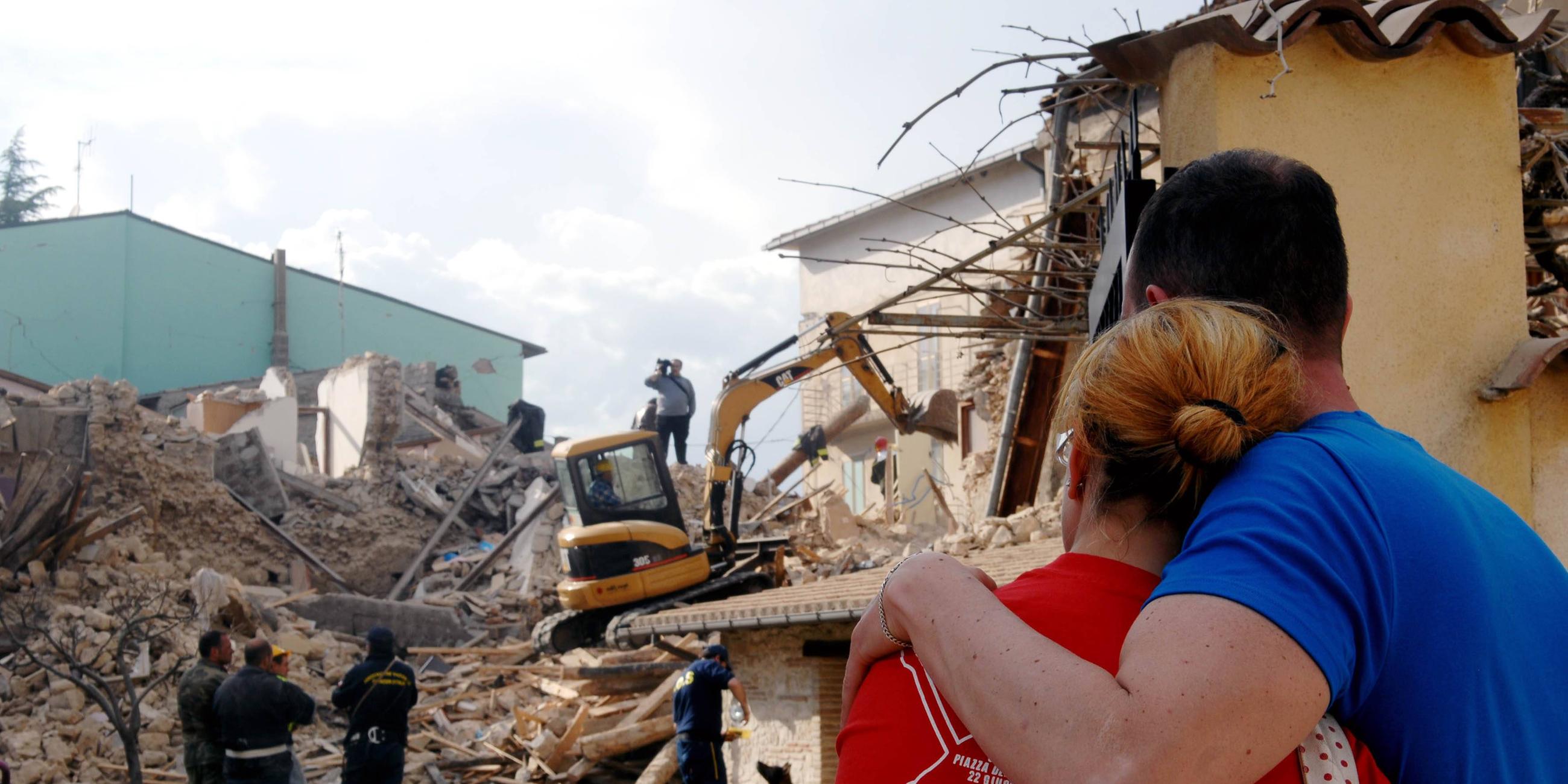 Erdbebenopfer beobachten die Suche der Rettungskräfte in den Trümmern ihres eingestürzten Hauses.
