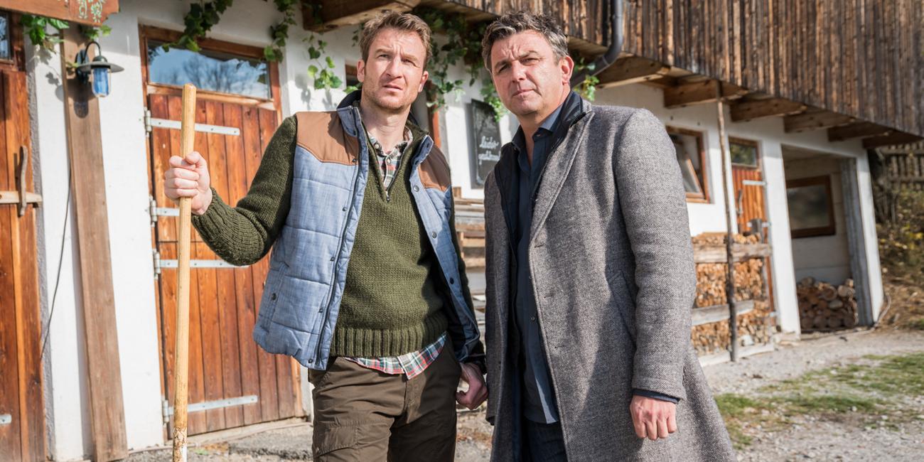 "Der Bergdoktor: Zeit der Wölfe (1)": Hans Gruber (Heiko Ruprecht) und Dr. Martin Gruber (Hans Sigl) stehen nebeneinander auf dem Hof und blicken nachdenklich in die Ferne.