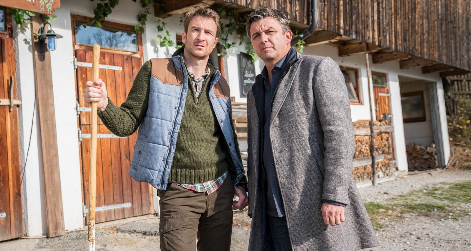 "Der Bergdoktor: Zeit der Wölfe (1)": Hans Gruber (Heiko Ruprecht) und Dr. Martin Gruber (Hans Sigl) stehen nebeneinander auf dem Hof und blicken nachdenklich in die Ferne.