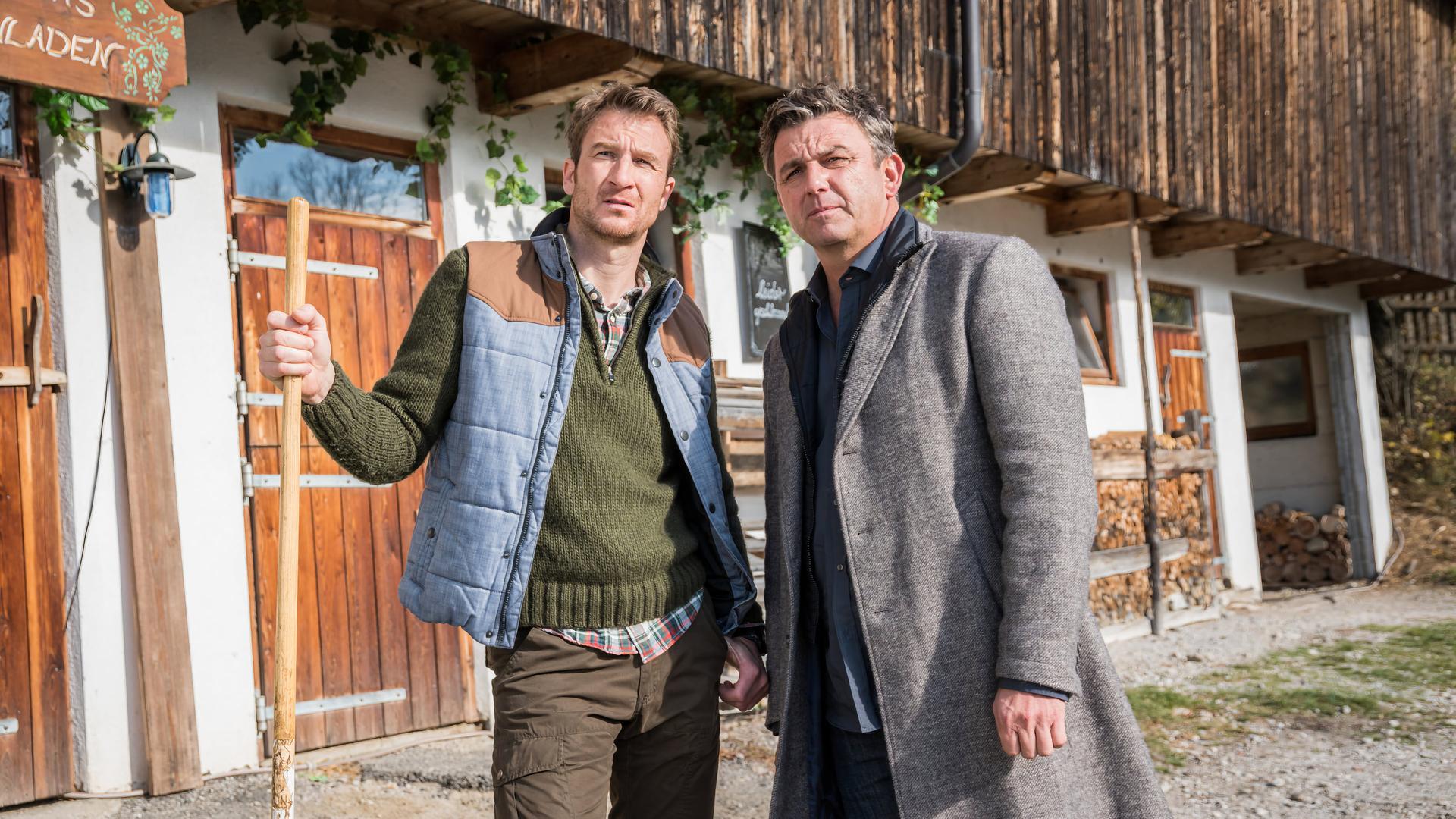 "Der Bergdoktor: Zeit der Wölfe (1)": Hans Gruber (Heiko Ruprecht) und Dr. Martin Gruber (Hans Sigl) stehen nebeneinander auf dem Hof und blicken nachdenklich in die Ferne.