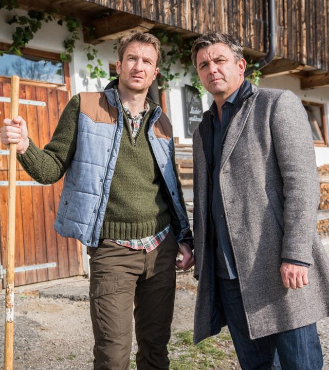 "Der Bergdoktor: Zeit der Wölfe (1)": Hans Gruber (Heiko Ruprecht) und Dr. Martin Gruber (Hans Sigl) stehen nebeneinander auf dem Hof und blicken nachdenklich in die Ferne.