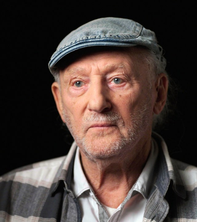 Bernard Offen sitzt vor einem schwarzen Hintergrund