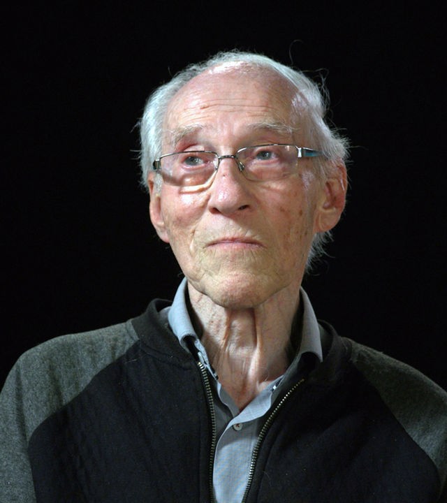 Henryk Joachims sitzt vor einem schwarzen Hintergrund 