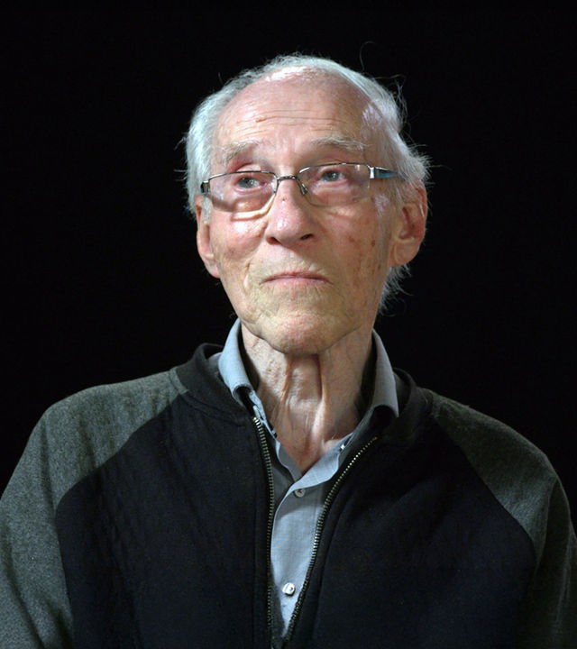 Henryk Joachims sitzt vor einem schwarzen Hintergrund 