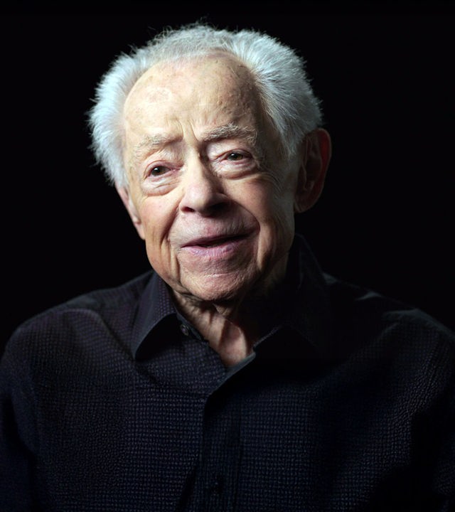 Mark Schonwetter sitzt vor einem schwarzen Hintergrund