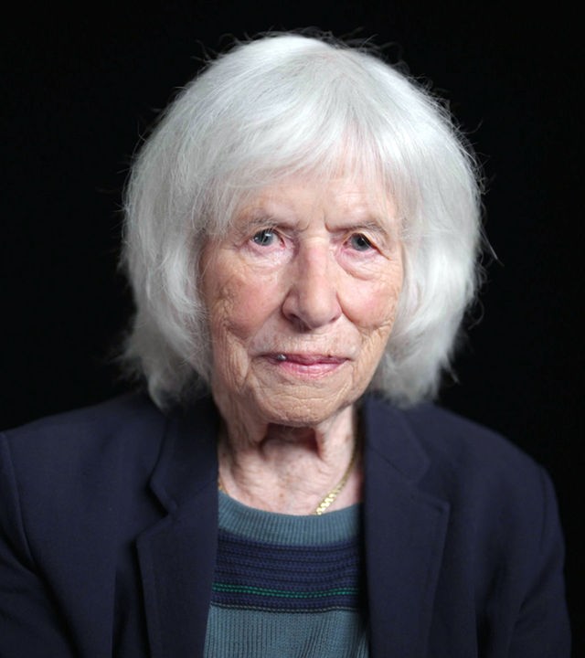 Nele Hertling sitzt vor einem schwarzen Hintergrund. 