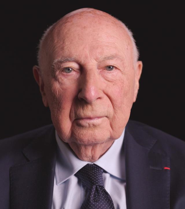 Holocaust Überlebender Pierre Kahn frontal vor schwarzem Hintergrund. 