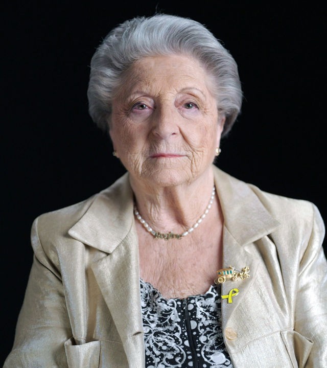 Regina Suchowolski Sluszny sitzt vor einem schwarzen Hintergrund. 