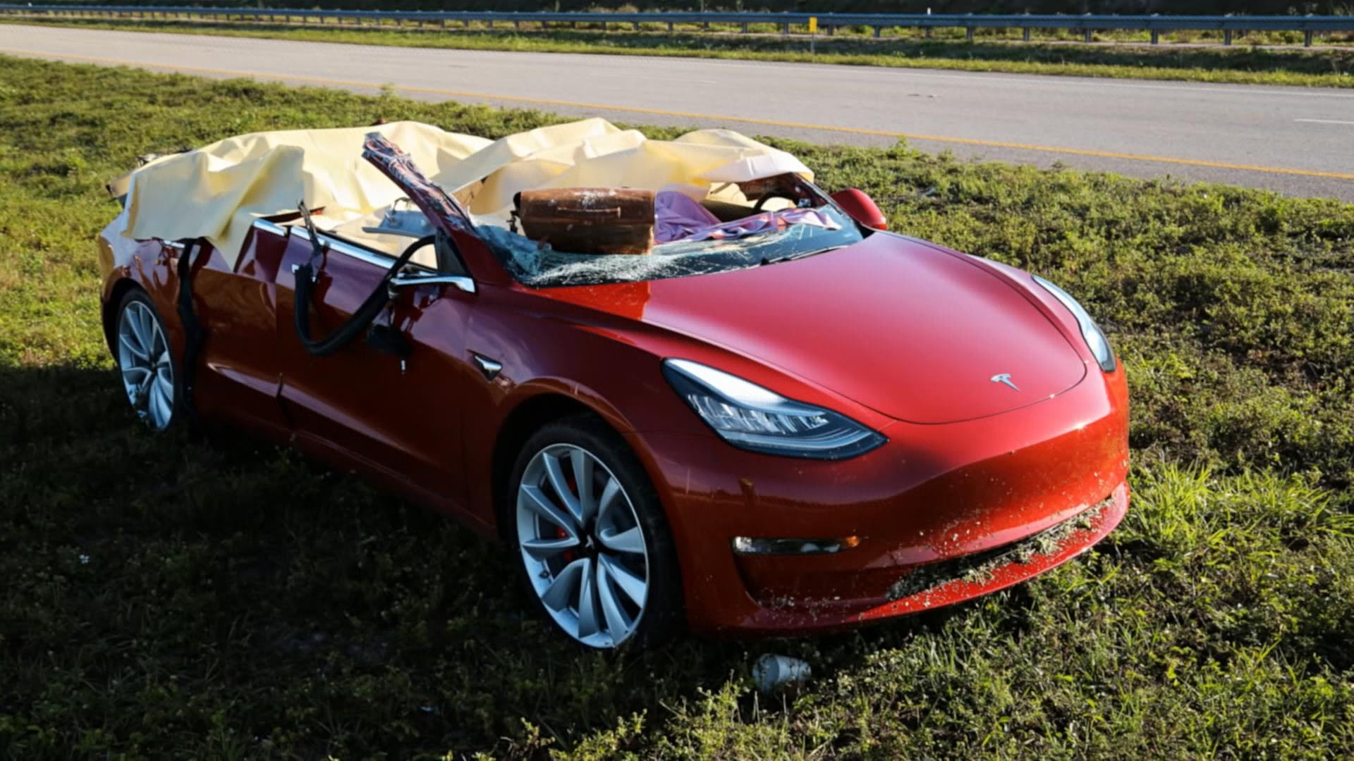 Zerstörtes Tesla-Fahrzeug nach Unfall auf Landstraße, Wagendach nicht mehr vorhanden
