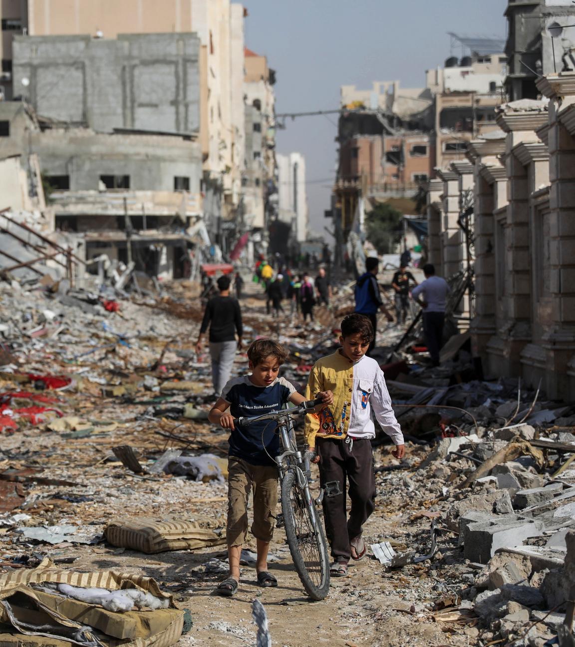 Archiv: Palästinenser gehen am  24. 11. 2023, durch die Zerstörung in Gaza-Stadt, als der vorübergehende Waffenstillstand zwischen Israel und der Hamas in Kraft trat.
