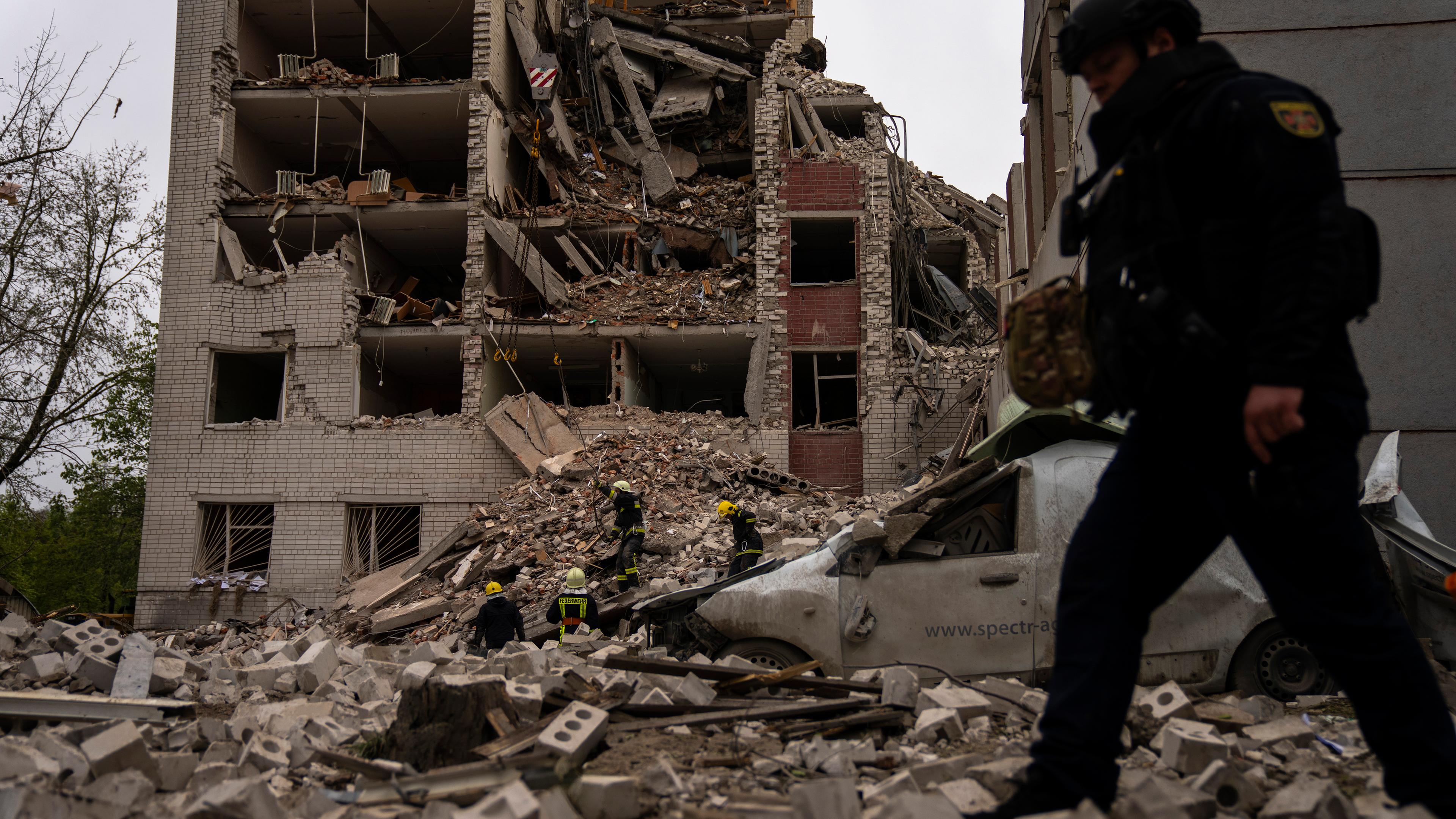 Feuerwehrleute arbeiten an einem Gebäude, das nach einem russischen Bombenangriff in Tschernihiw, Ukraine, am Mittwoch, 17. April 2024, teilweise zerstört wurde.
