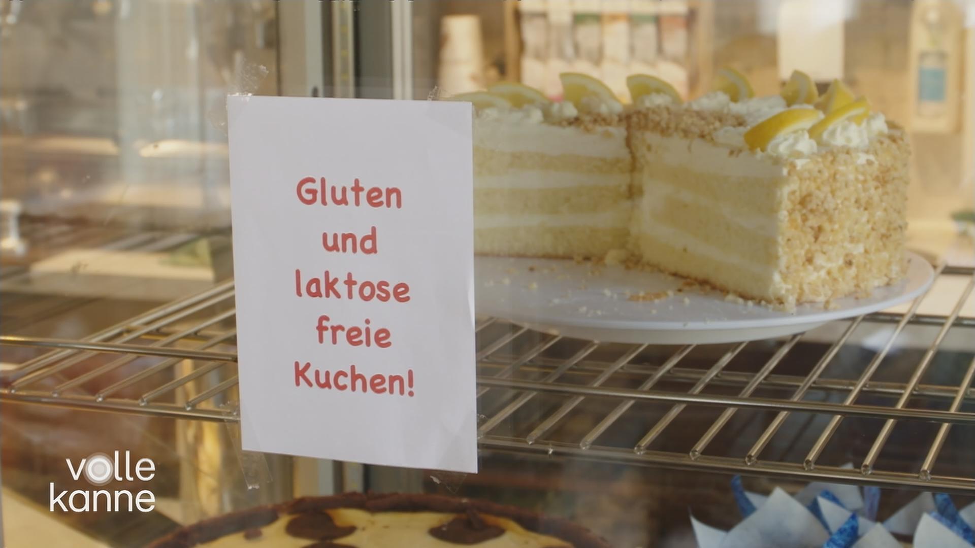 Kuchen-Theke mit Zettel an der Scheibe auf dem steht: "Gluten und laktose freie Kuchen"