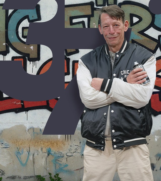 Mann in Lederjacke vor Graffitywand