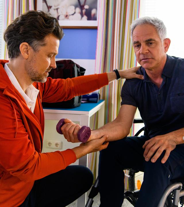 "Bettys Diagnose : Zu schnell zu viel": David Weber (Wayne Carpendale) macht mit Prof. Dr. Alexander von Arnstett (Florian Fitz), der im Rollstuhl sitzt, Hanteltraining.