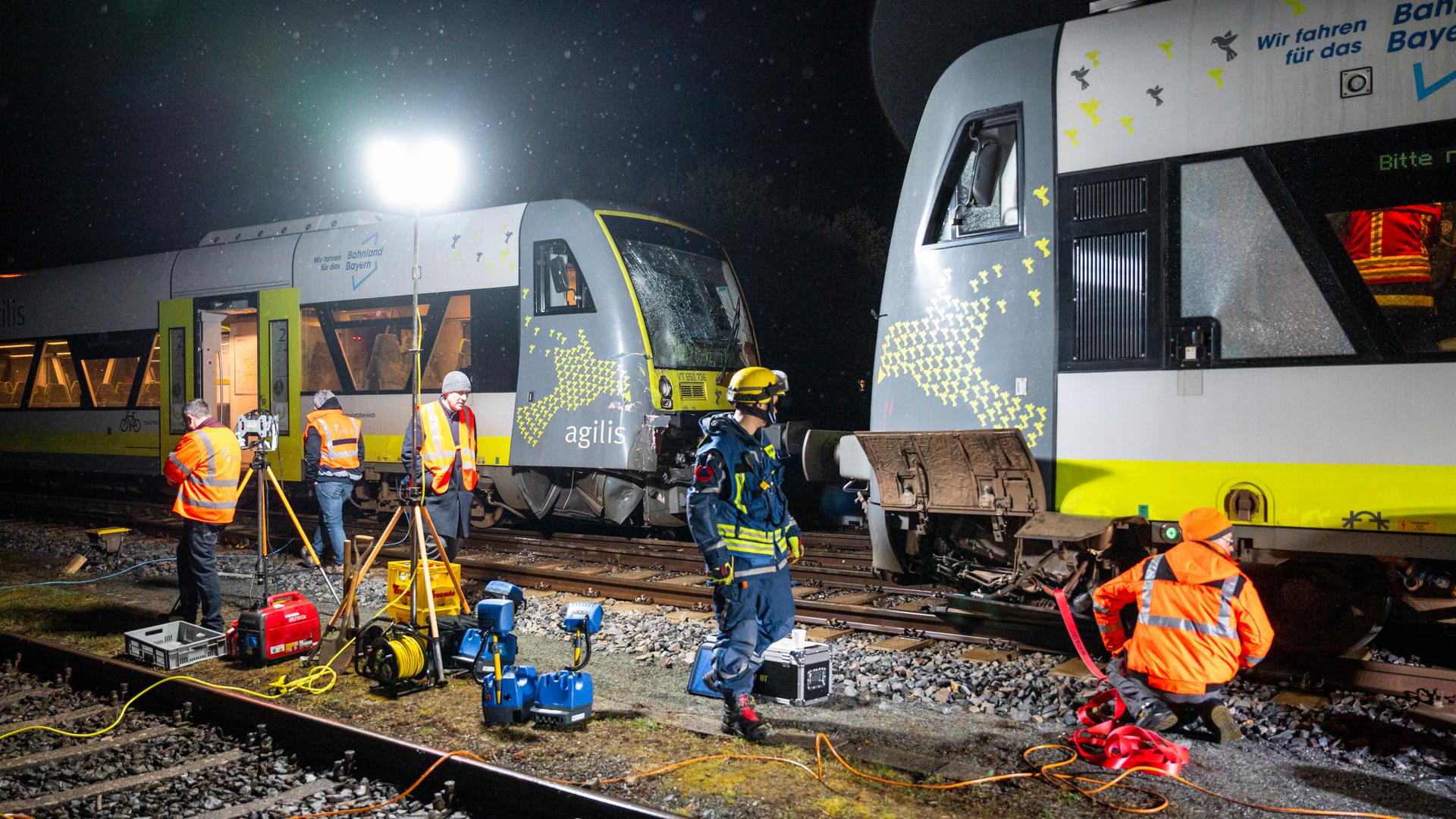 Einsatzkräfte des THW und der Agilis Verkehrsgesellschaft führen Arbeiten an den kollidierten Zügen aus, damit diese von den Gleisen abtransportiert werden können. 