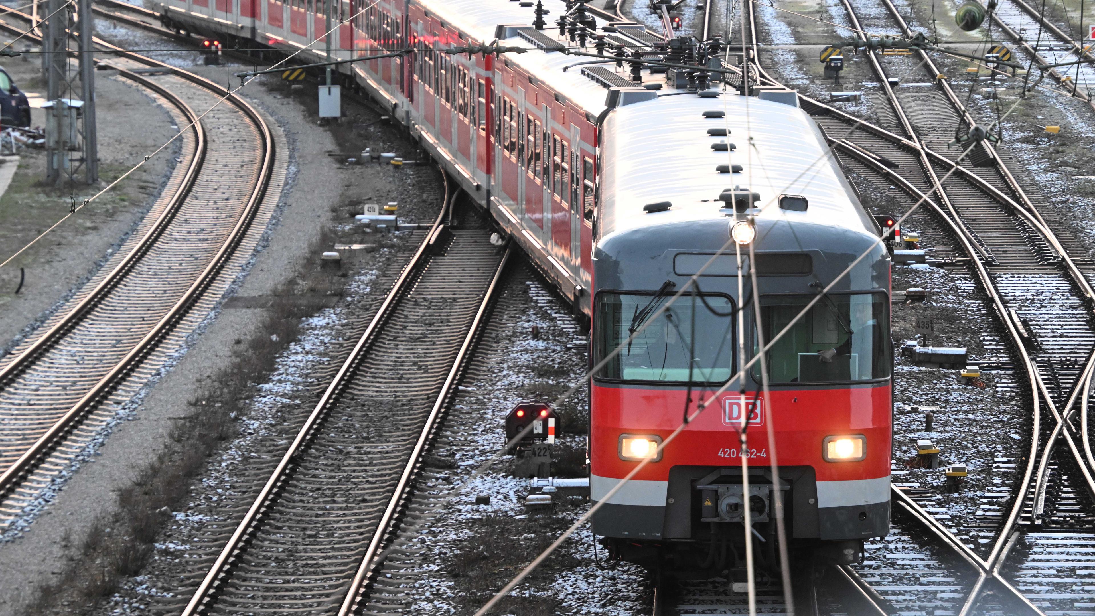 Ein roter Regionalzug der Deutschen Bahn auf den Gleisen; München; 28.03.2023