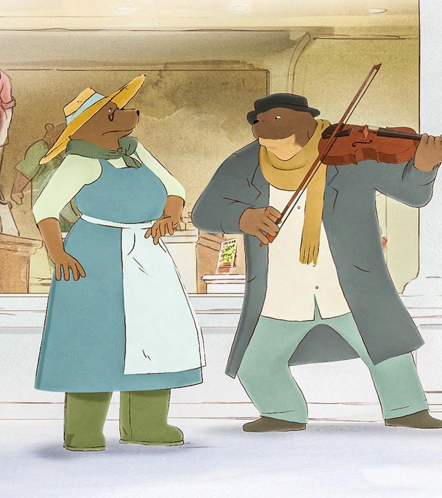 Madame Tulipe (l.), Ernest (m.) und Monsieur Martin (r.) stehen vorm Kaufhaus. Ernest spielt für die beiden ein Lied auf seiner Geige.