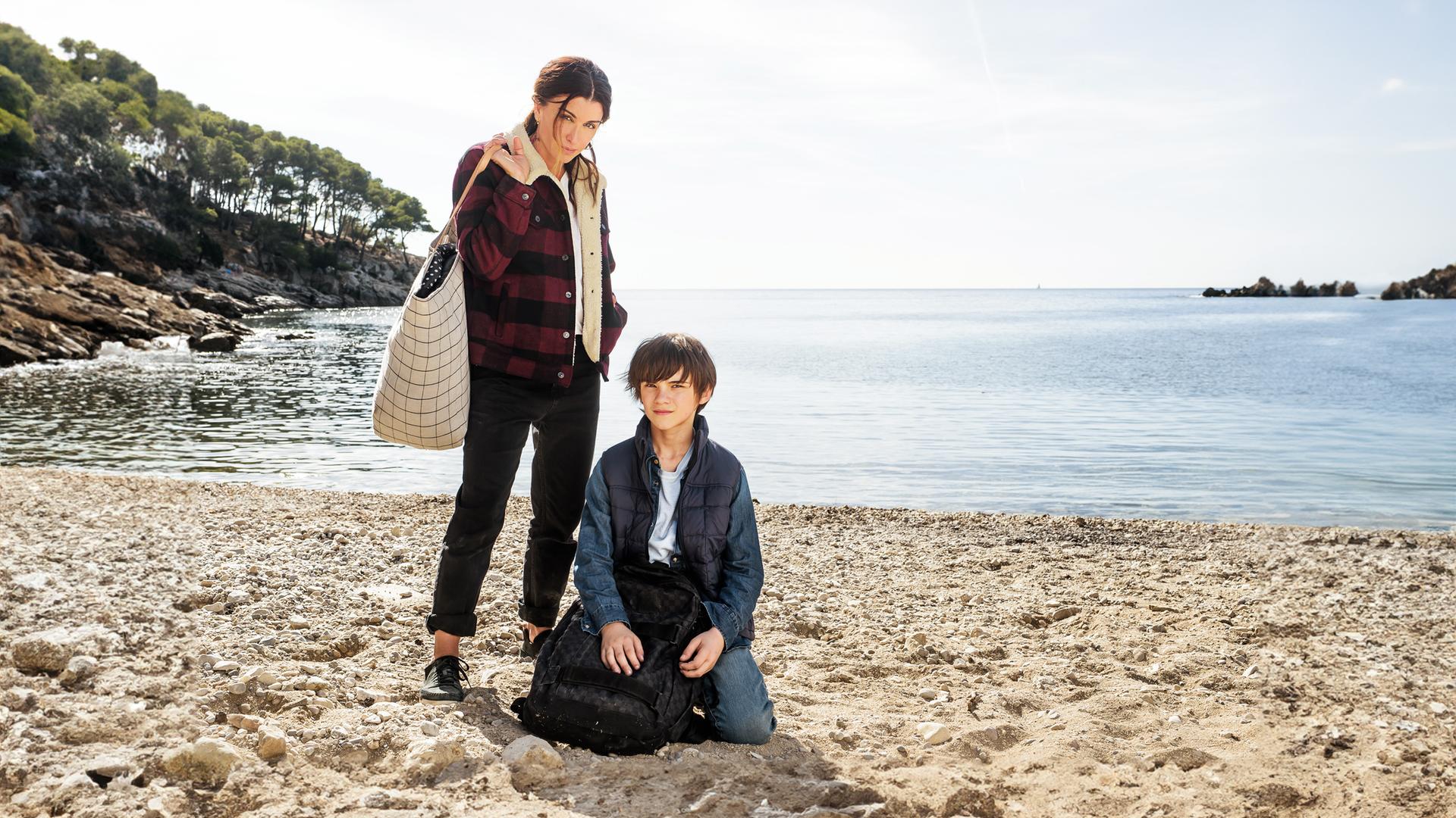 "Zwei auf der Flucht": Sarah (Jenifer Bartoli) und Léo (Félix Bossuet) befinden sich an einem Strand und blicken ernst nach vorne in Richtung Kamera.