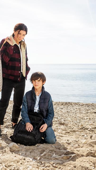 "Zwei auf der Flucht": Sarah (Jenifer Bartoli) und Léo (Félix Bossuet) befinden sich an einem Strand und blicken ernst nach vorne in Richtung Kamera.