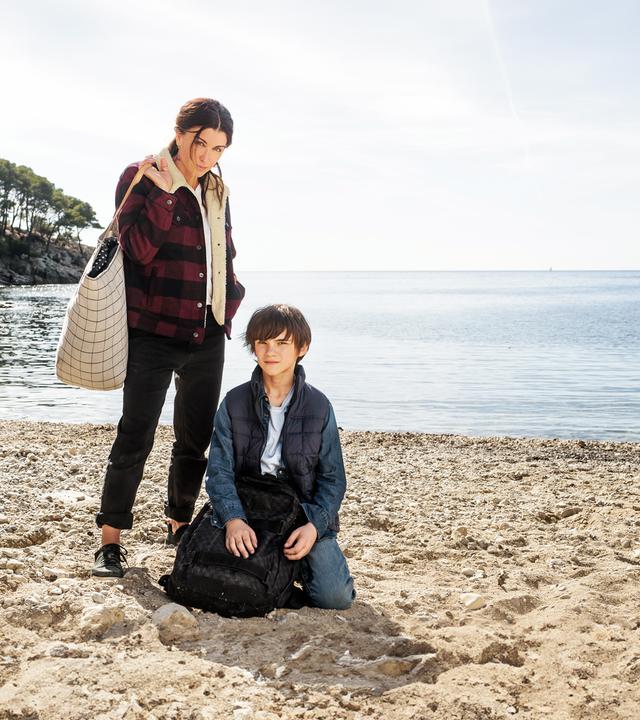 "Zwei auf der Flucht": Sarah (Jenifer Bartoli) und Léo (Félix Bossuet) befinden sich an einem Strand und blicken ernst nach vorne in Richtung Kamera.